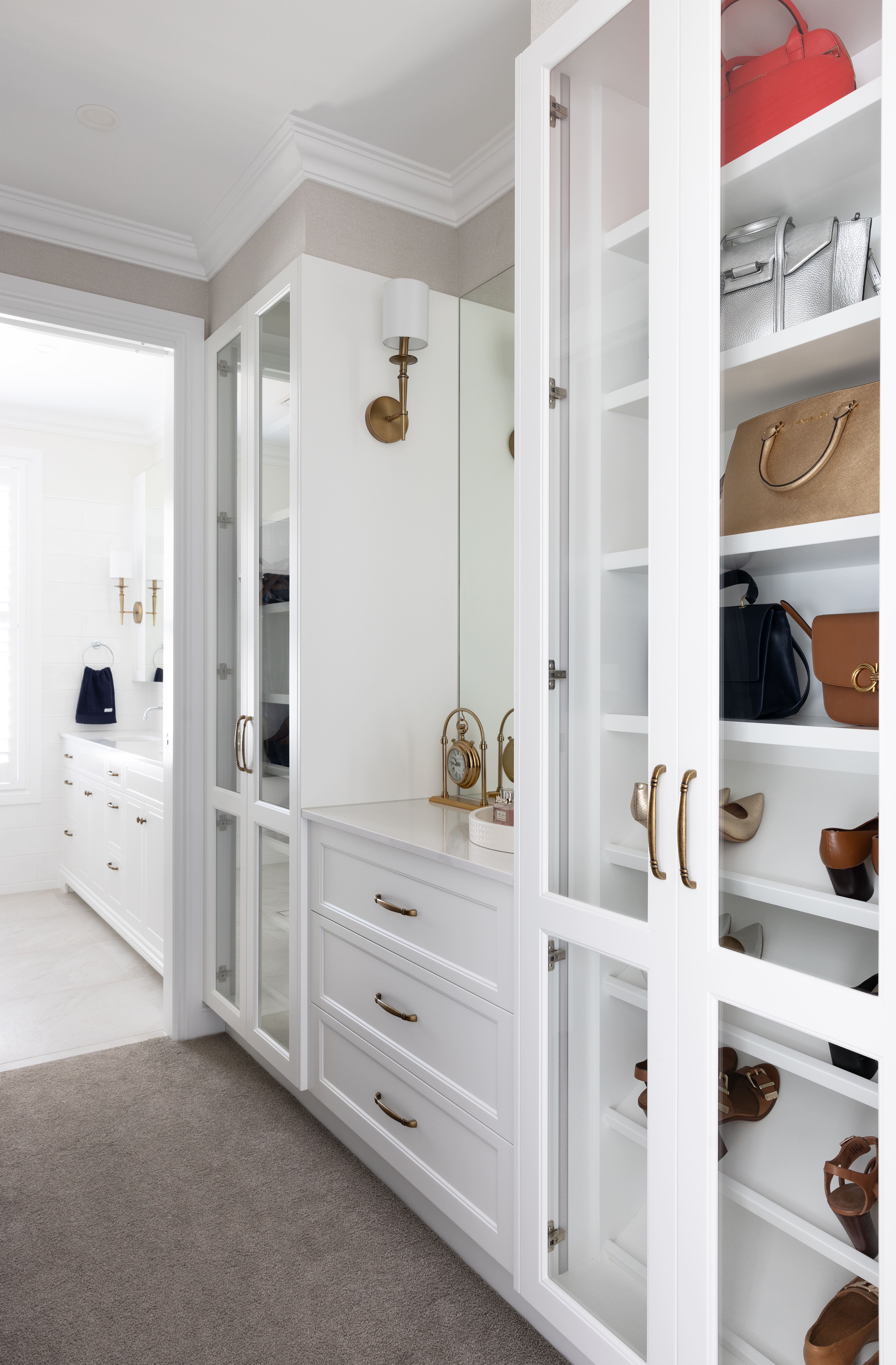 Walk in wardrobe with glass front cupboards and drawers