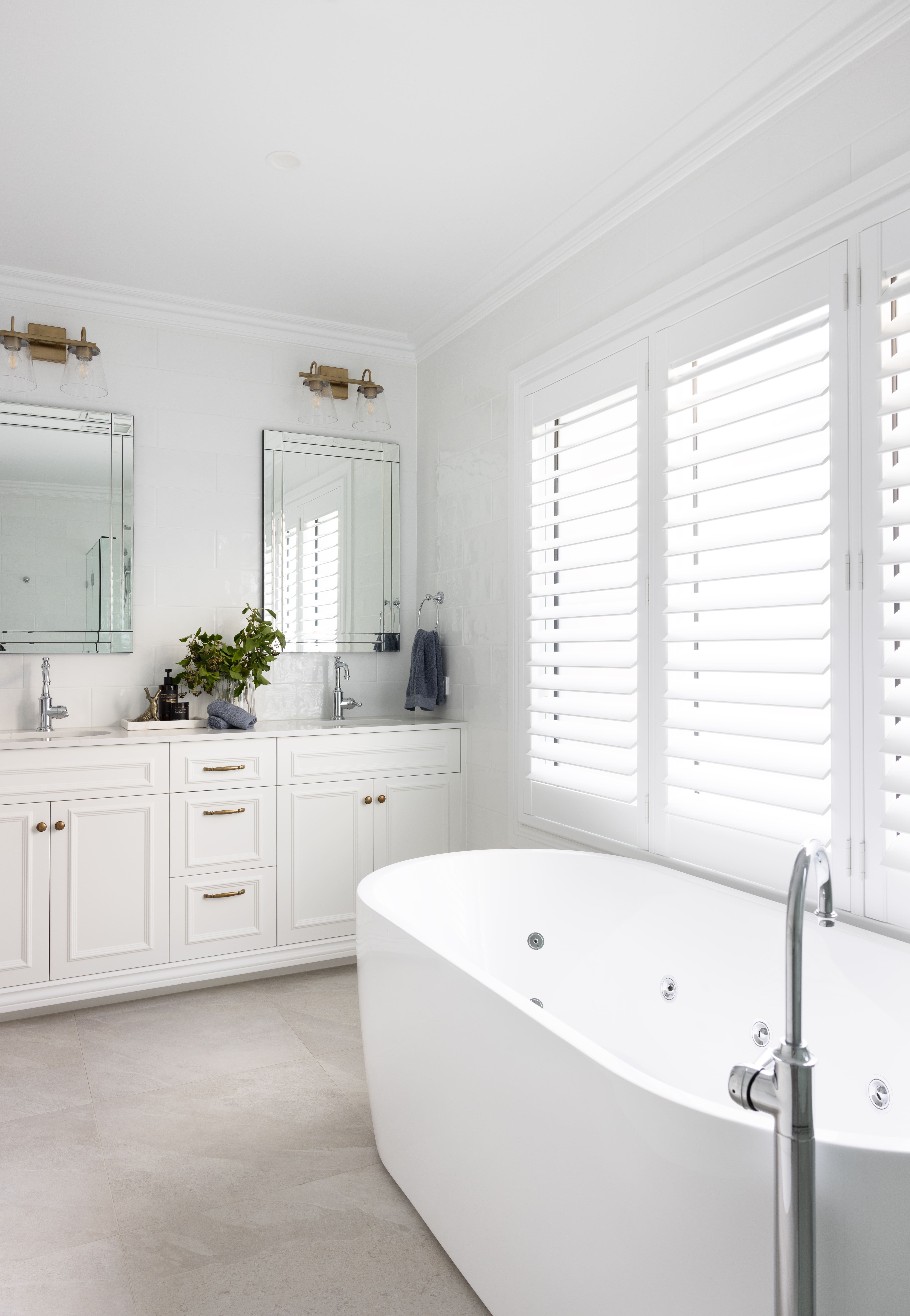 Ensuite bathroom with plantation shutters, dual vanity with dual mirrors and freestanding bath