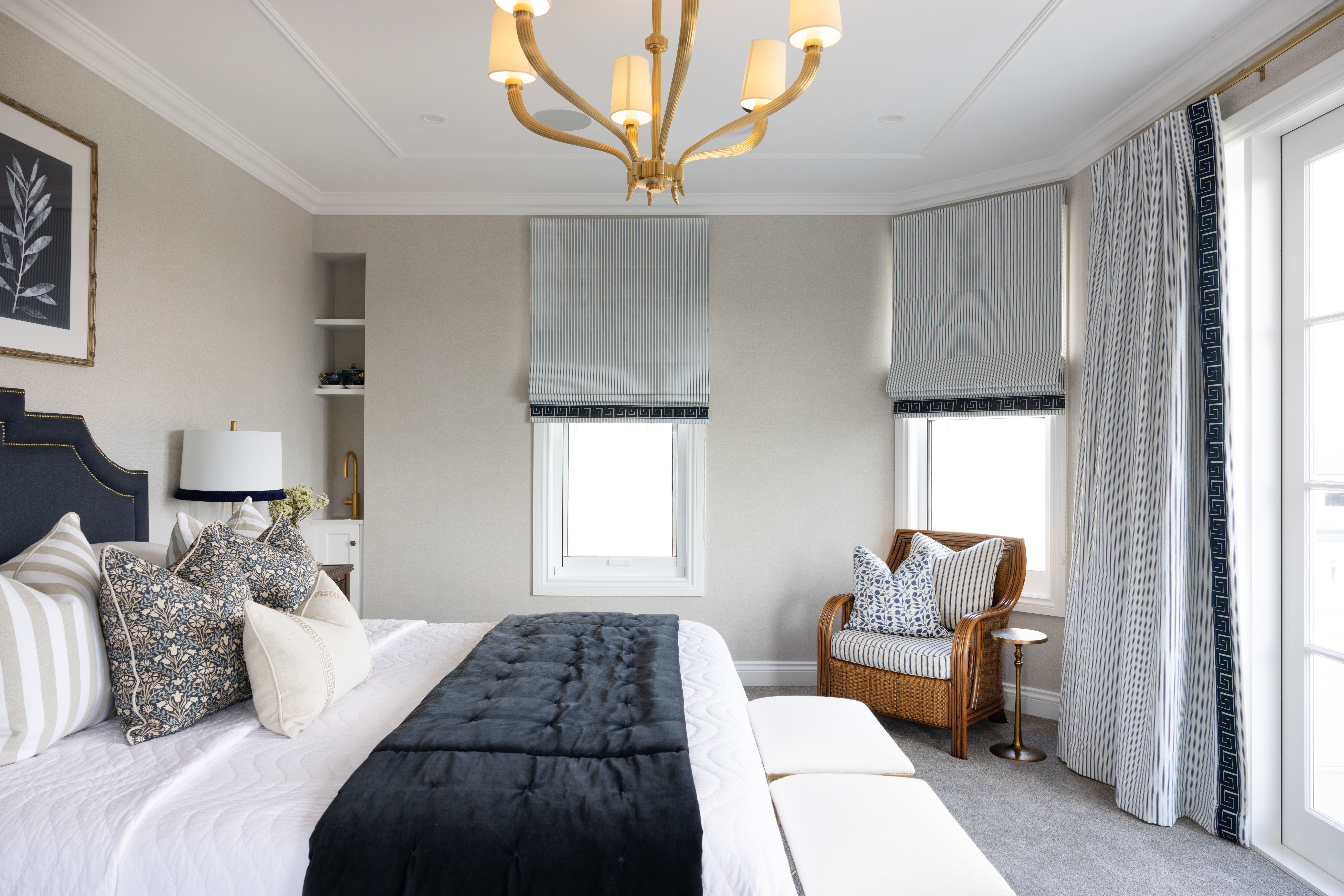 Bedroom with feature light and navy and white styling.