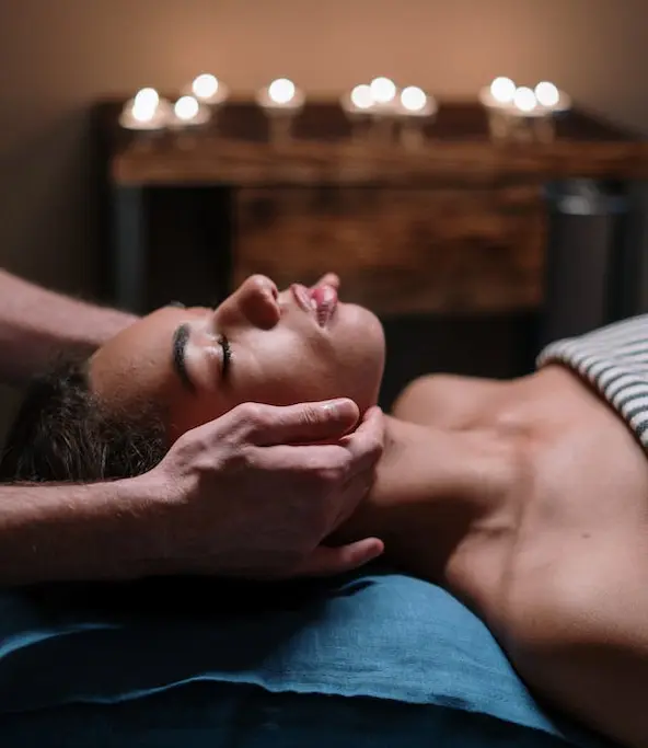 Visage serein d’une femme recevant un massage lemniscate, moment de relaxation profonde.