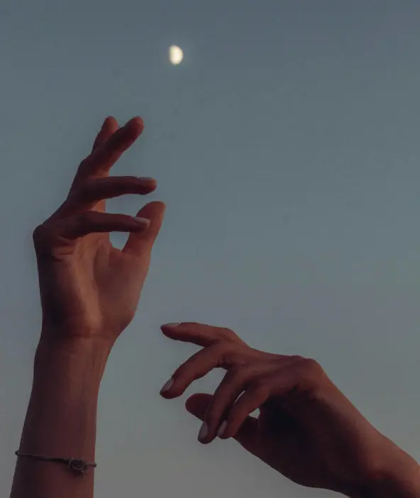 Mains ouvertes devant un ciel bleu, symbole de relaxation.