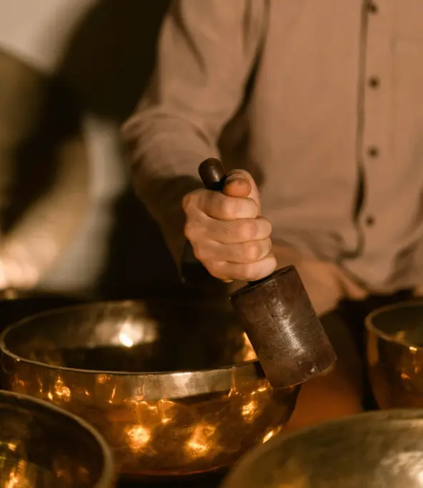 Praticien utilisant un bol Kansu lors d’une séance de réflexologie plantaire.