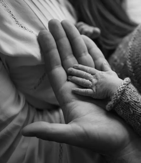 Séance de réflexologie pédiatrique et périnatalité, mains bébé et praticien.