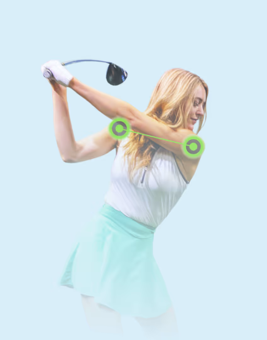 Female golfer mid-backswing with shoulder alignment markers.