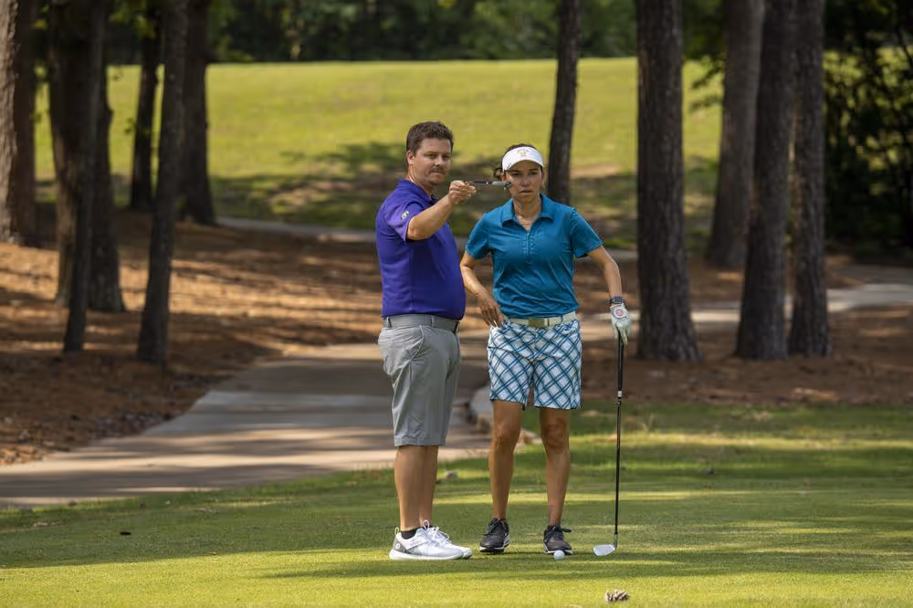 Golfer getting on course lesson from GOLFTEC Coach