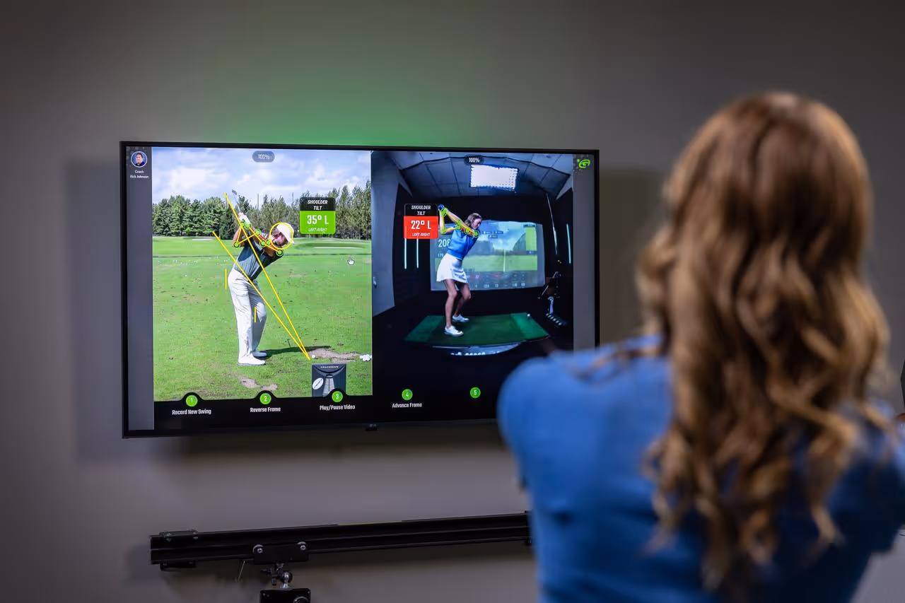 A person viewing a golf swing analysis on a screen showing two images comparing shoulder tilt angles during a golf swing.
