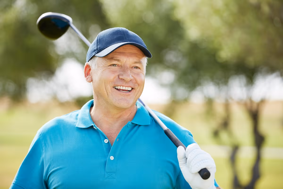 A happy senior golfer practicing his swing during a personalized GOLFTEC performance session, utilizing 3D biomechanical feedback to improve swing consistency and efficiency for his age group.