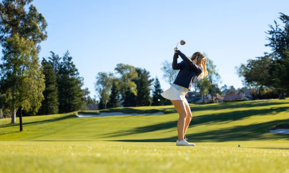 beginner golfer on fairway ready to hit her shot