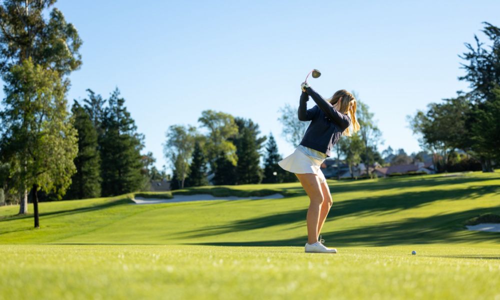 beginner golfer on fairway ready to hit her shot