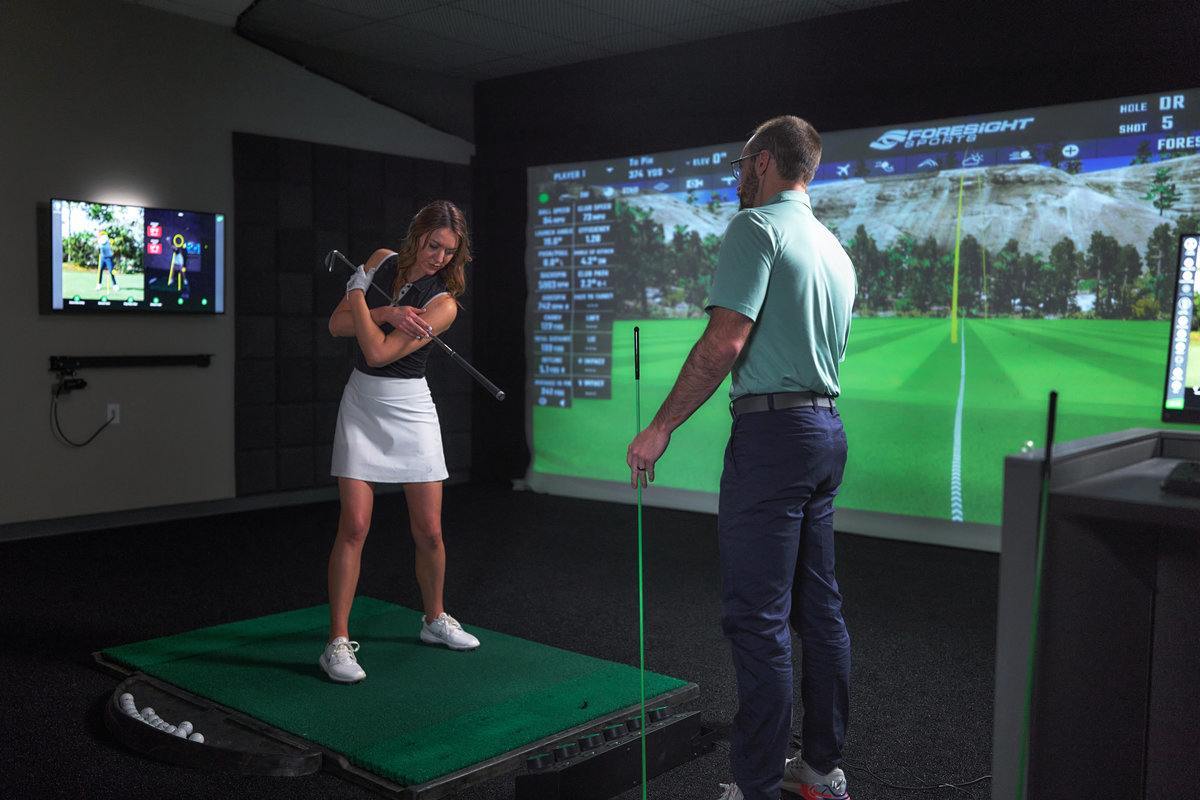 women golfer with coach standing nearby