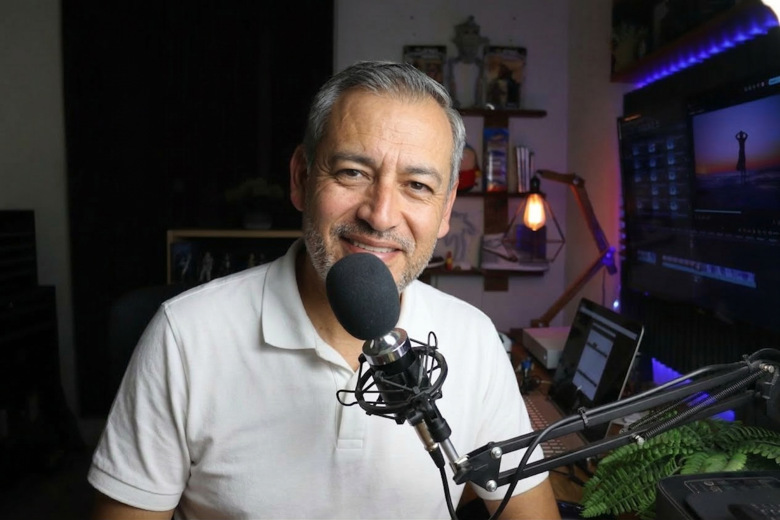 man in white shirt speaking in a microphone 