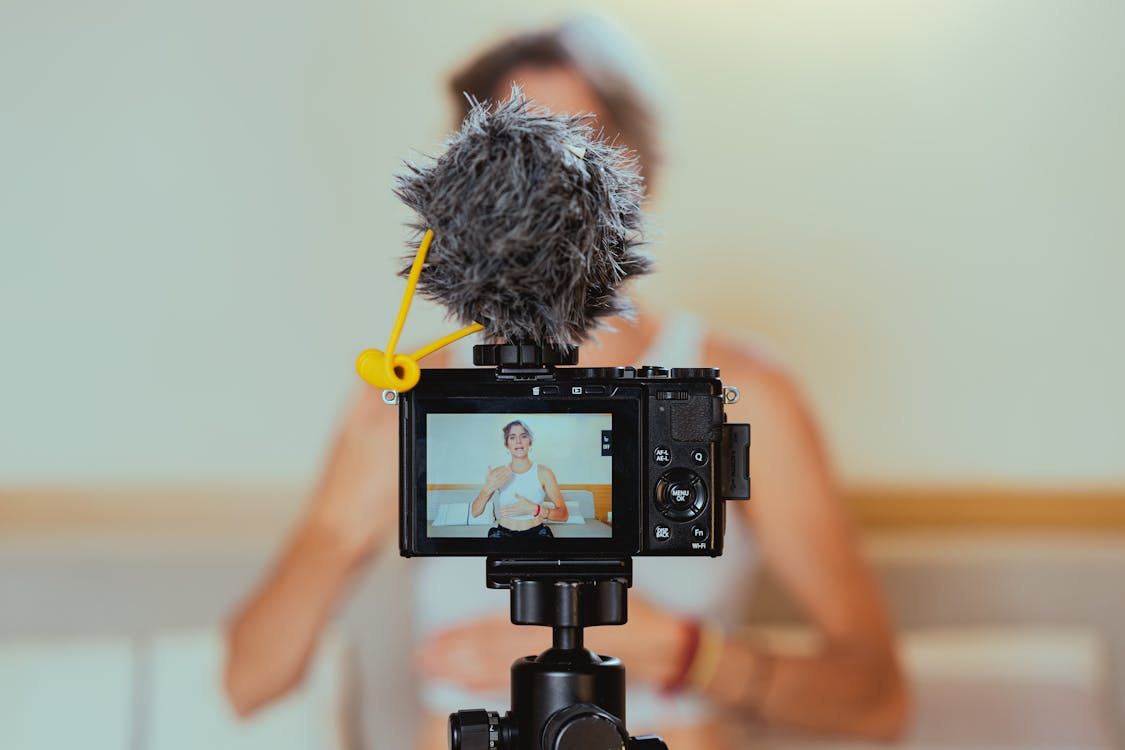  shallow focus photo of a video camera recording an elderly woman