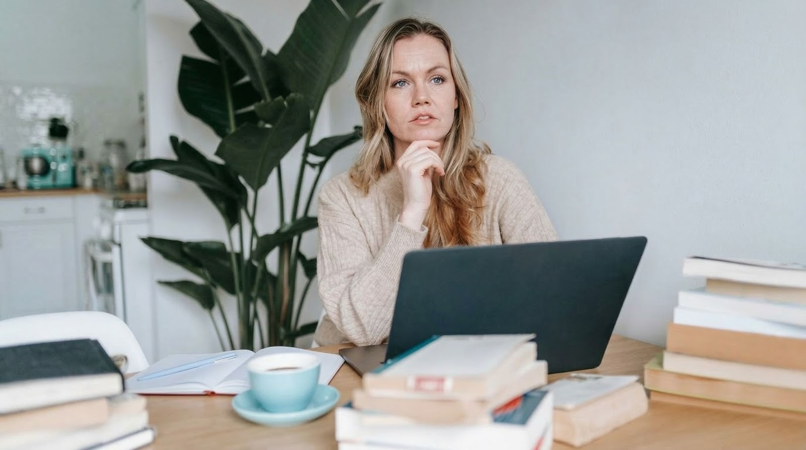  focused businesswoman thinking on project at laptop at home