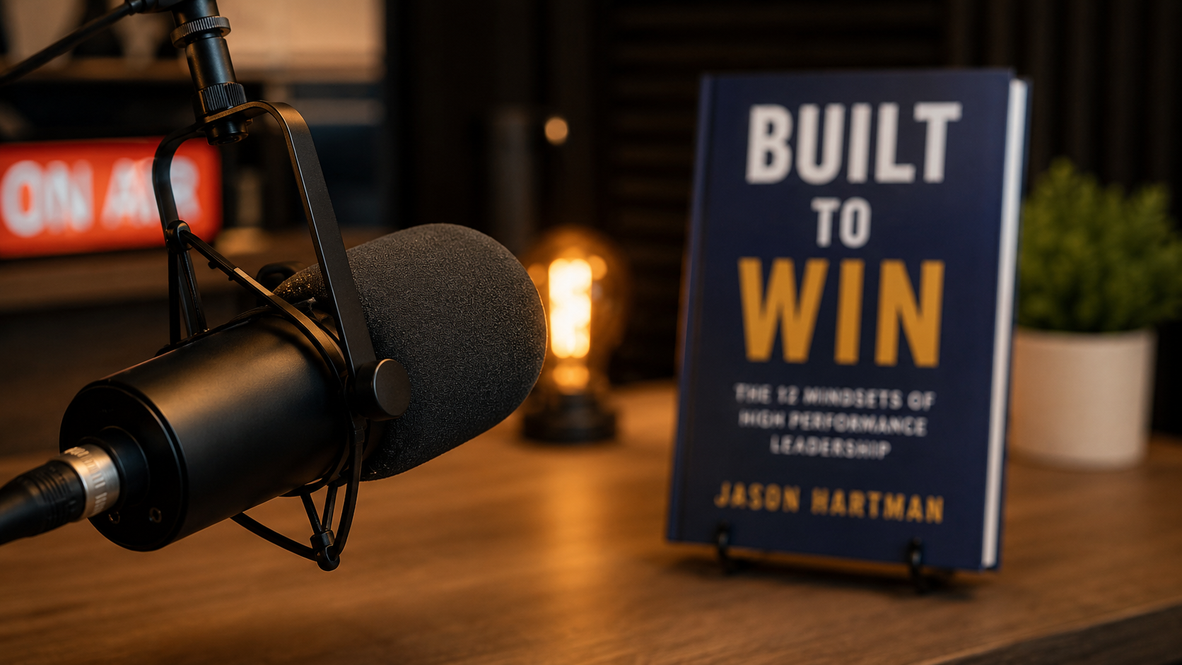 Close-up of a podcast microphone with a book visible in the background