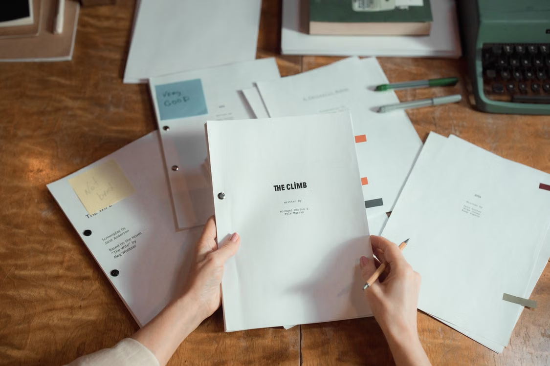 Handwritten manuscript notes and revision markups spread across a writer's desk