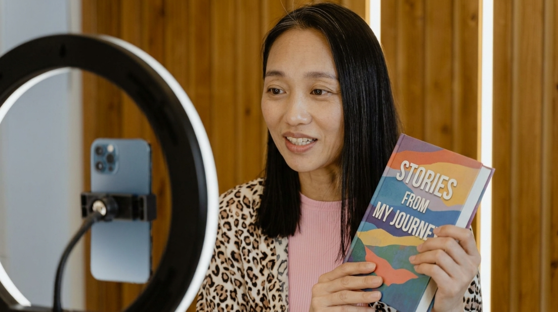 An author recording a short video clip on a phone tripod to promote their upcoming book