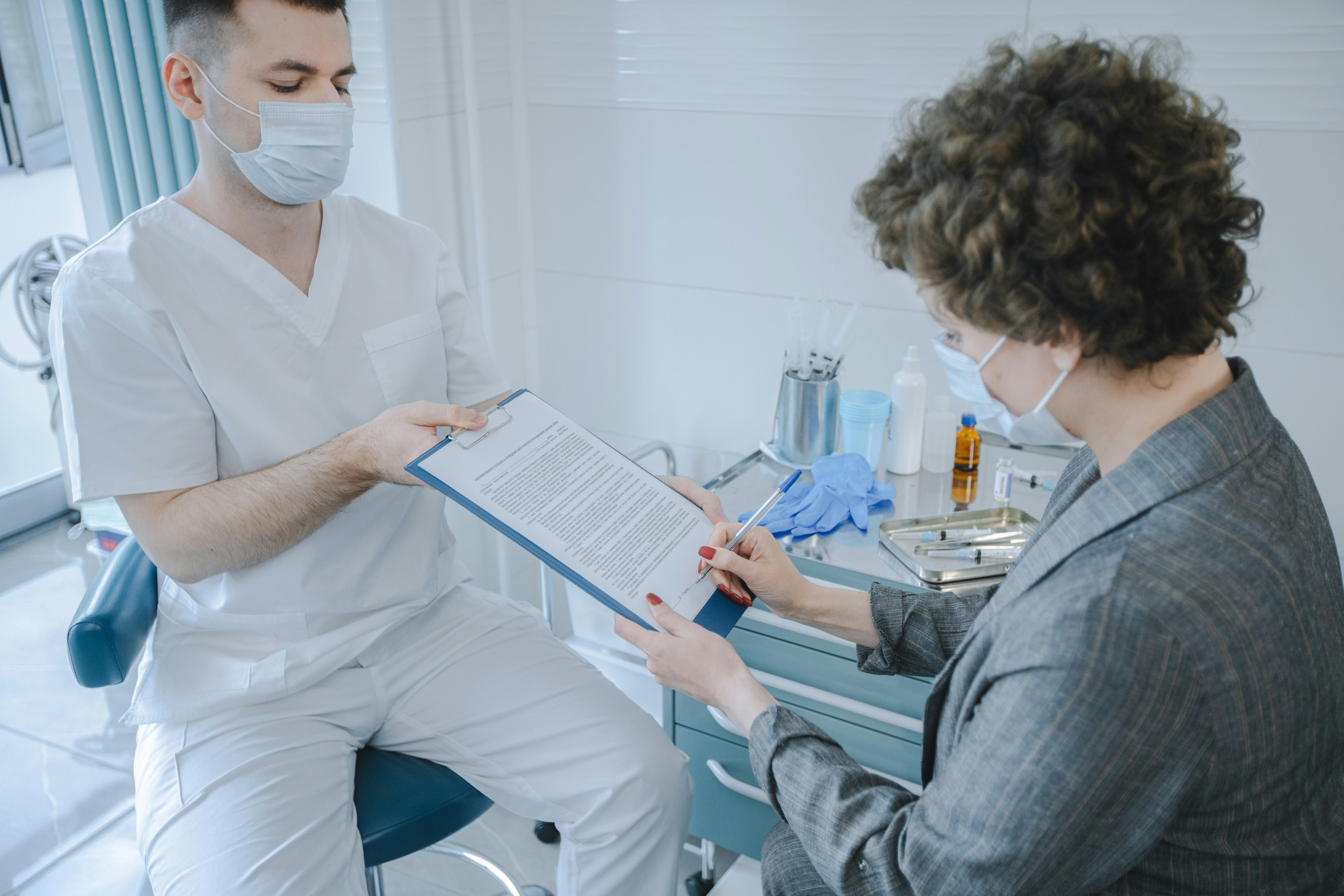 A medical professional and patient reviewing documents in a clinic setting.