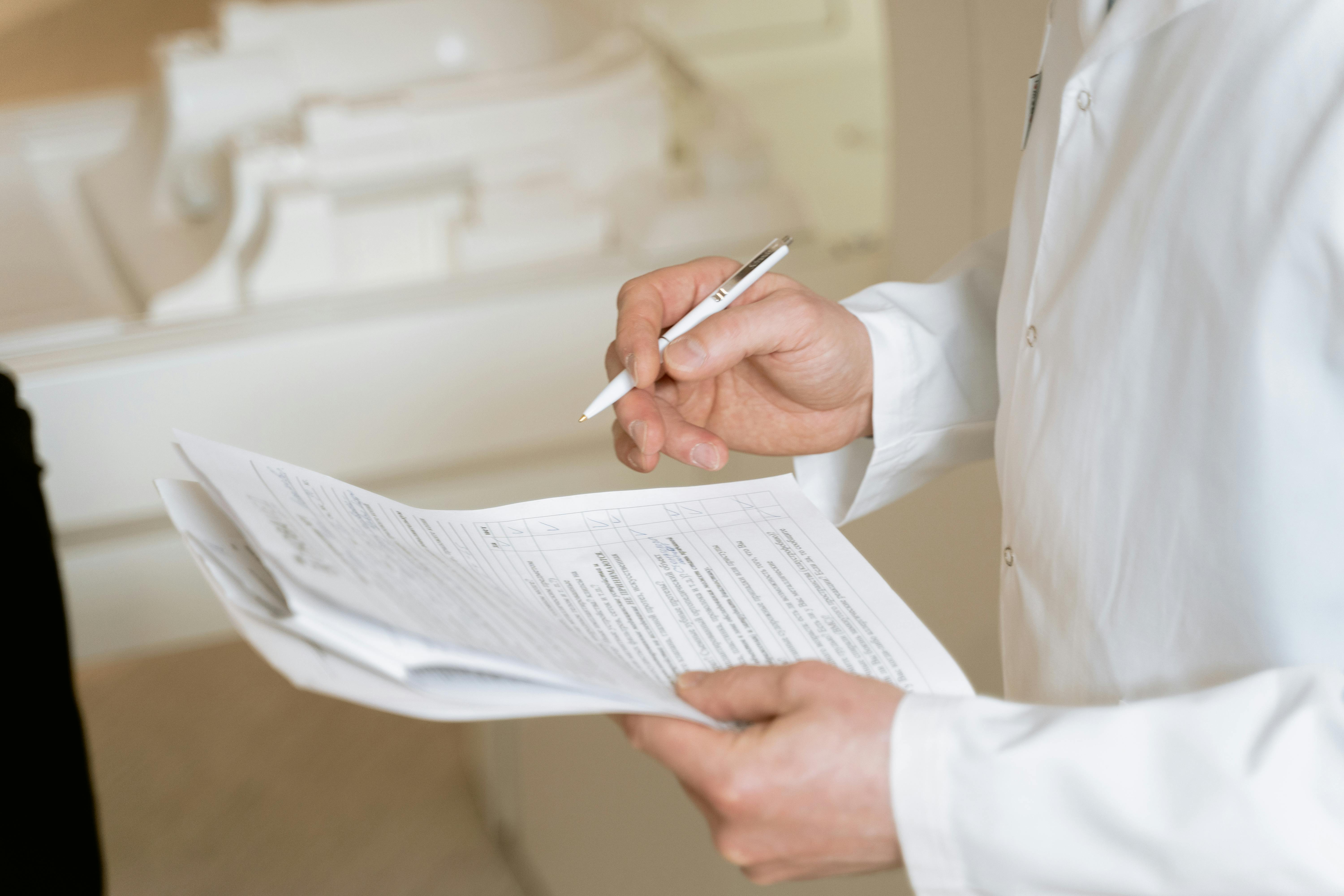 A doctor holds and reviews medical documents, demonstrating careful examination and professionalism.