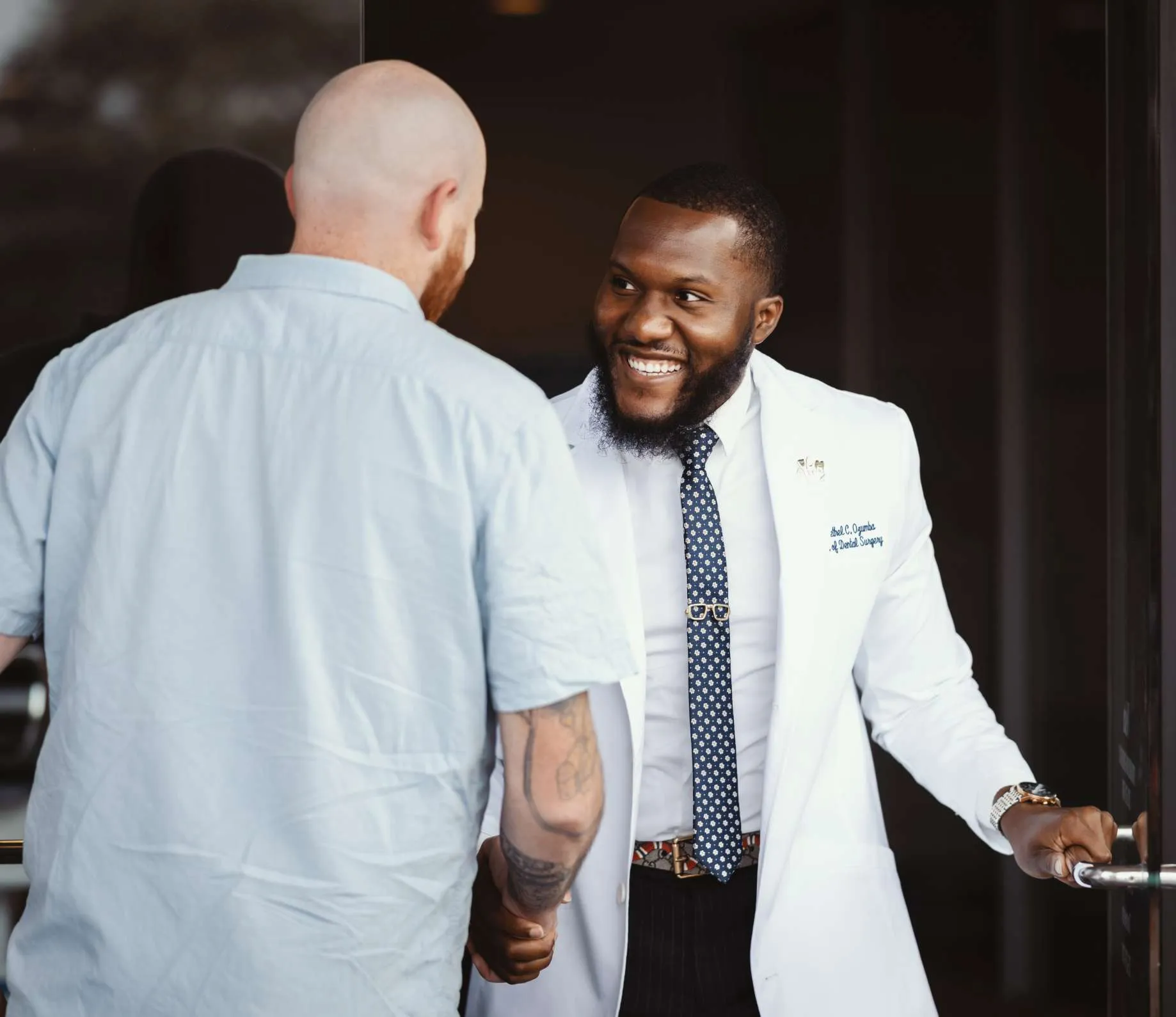 Dr. Ozumba welcoming a male patient to his practice