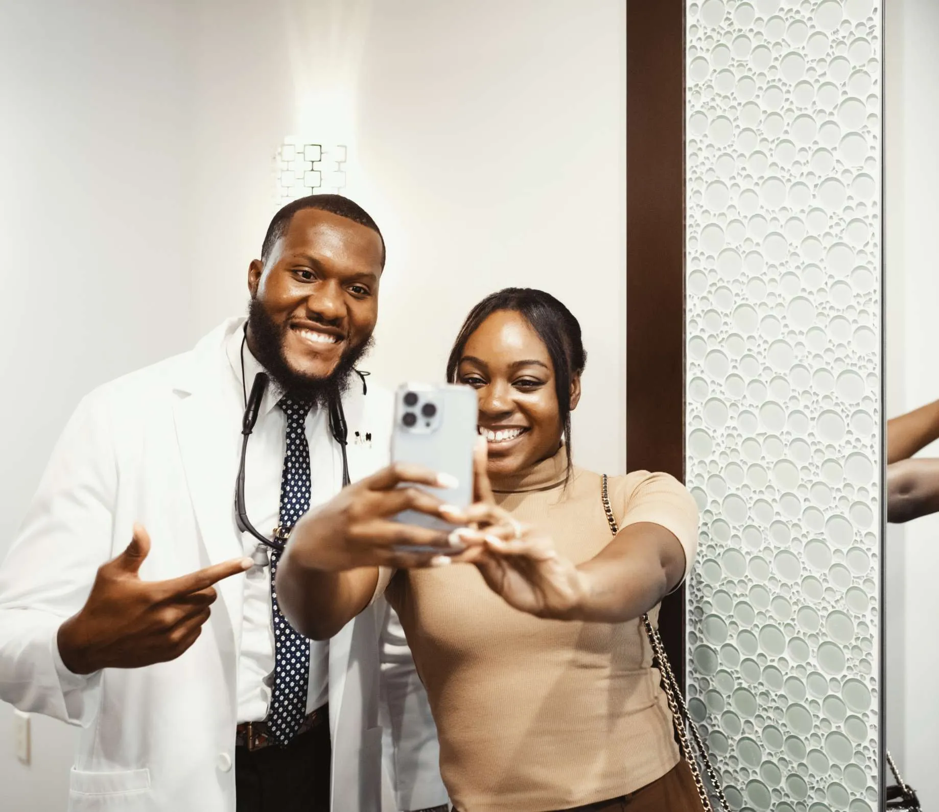 Dr. Ozumba smiling for a selfie with one his female patients