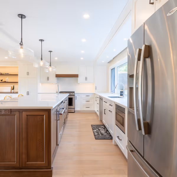 Modern kitchen cabinetry with built-in microwave and oven, open wooden shelves with mugs, coffee grinder, and decor items.
