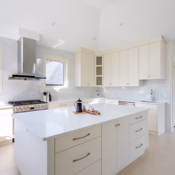 White kitchen cabinetry with glass upper cabinet doors, a counter with a coffee maker, and a wine cooler beneath the counter on a wooden floor.