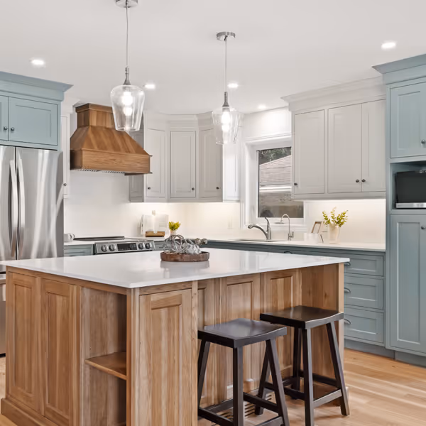 White kitchen cabinetry with glass upper cabinet doors, a counter with a coffee maker, and a wine cooler beneath the counter on a wooden floor.