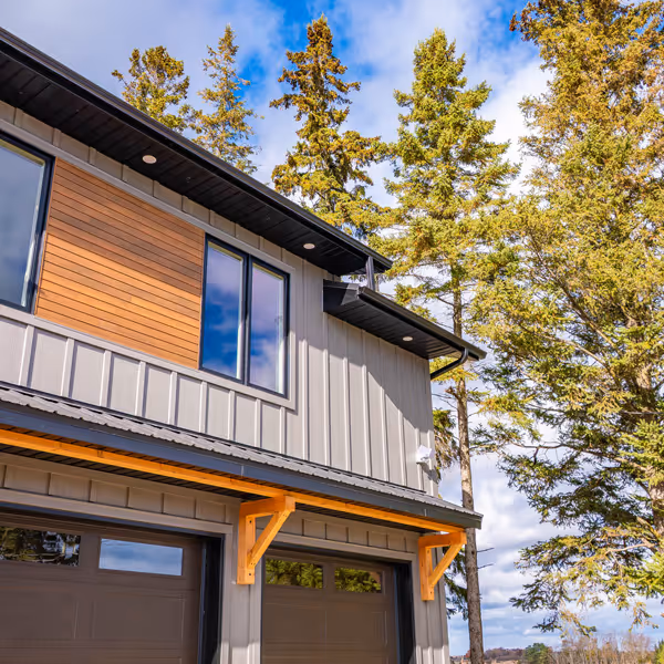 White kitchen cabinetry with glass upper cabinet doors, a counter with a coffee maker, and a wine cooler beneath the counter on a wooden floor.