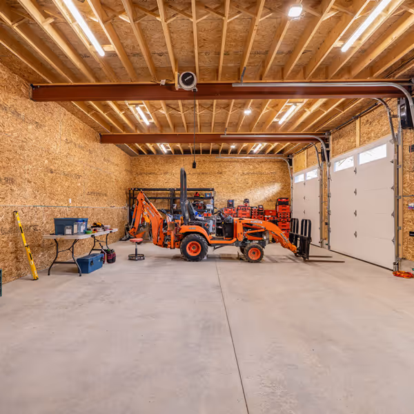 A bright modern bathroom with double vanity sinks, two rectangular mirrors, wall sconces, white cabinetry, and patterned tile floor.