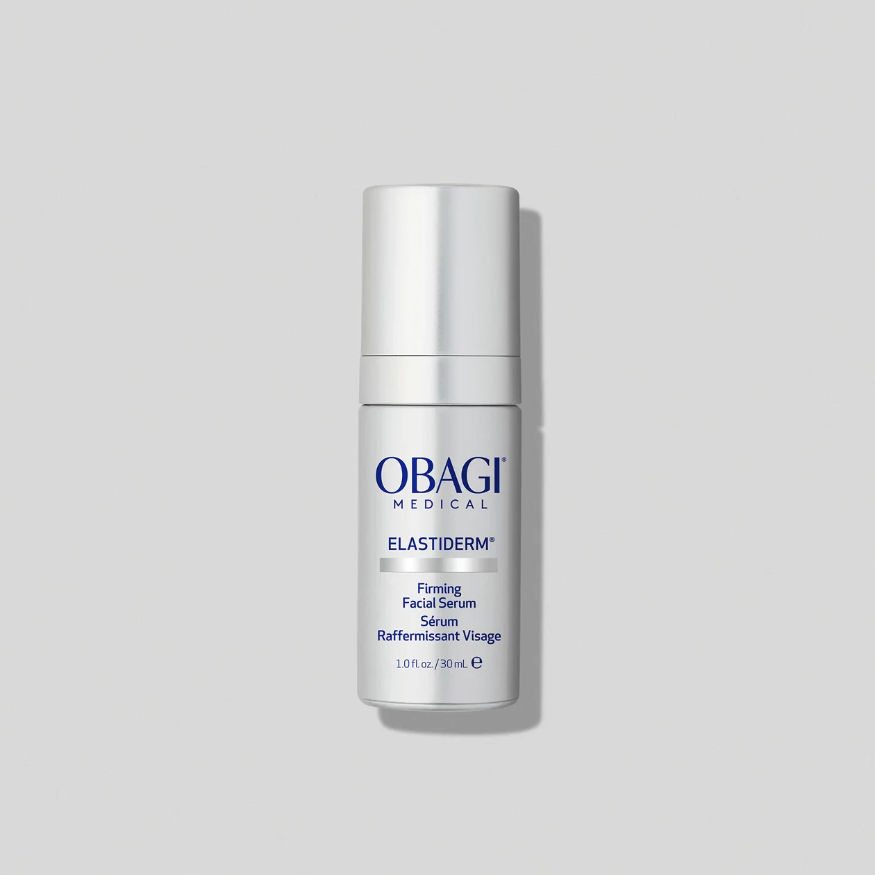 Obagi Medical Elastiderm Firming Facial Serum in a silver bottle on a light gray background.
