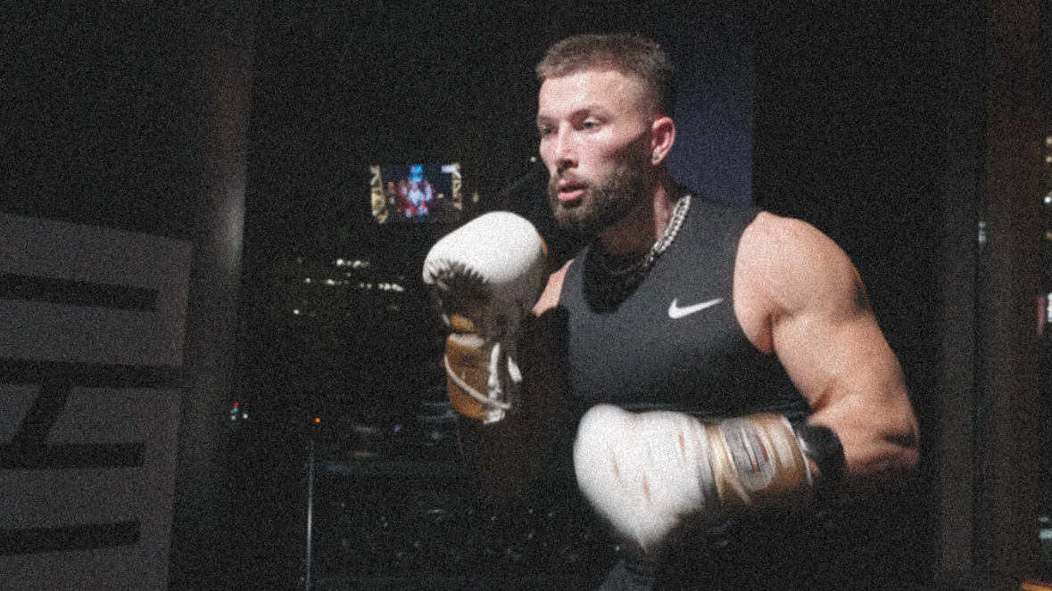 Jeremy wearing white boxing gloves about to hit a heavy bag