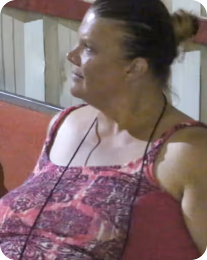 A woman sitting on a bench with a cell phone in her hand.