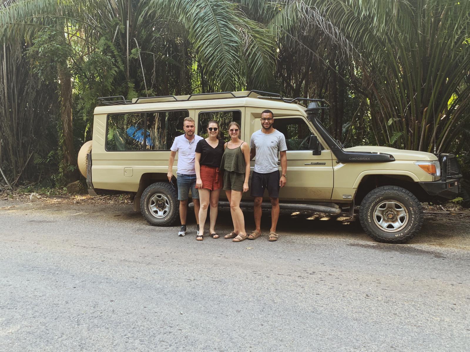 Eine Reisegruppe vor einem Safari Jeep