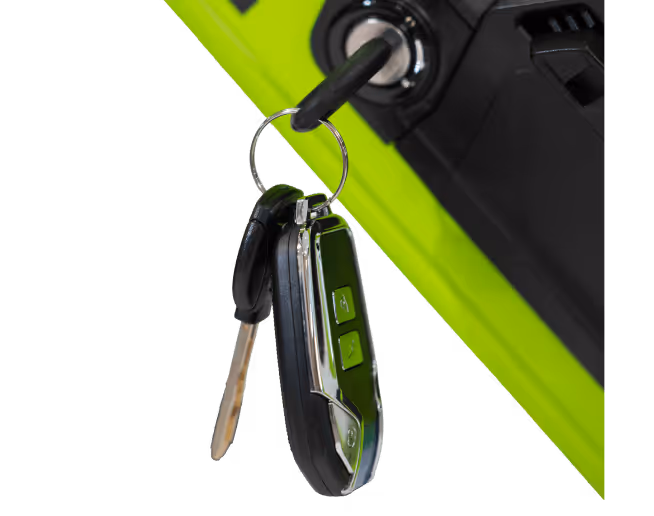Car key and remote on a keyring inserted into a vehicle's ignition with a bright green dashboard background.