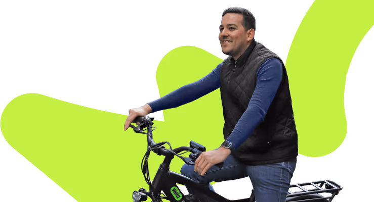 Man smiling and sitting on a black electric bike with a lime green abstract background shape.