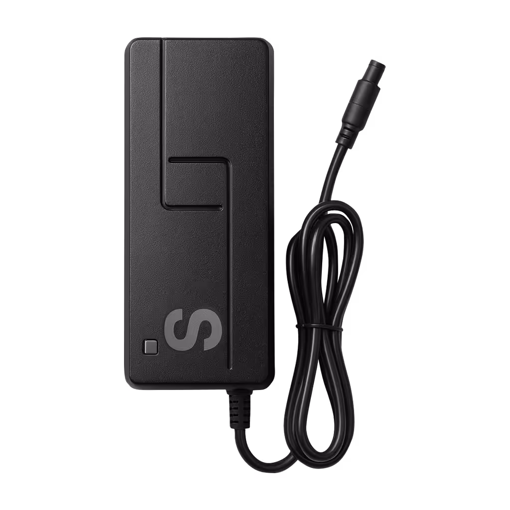 Black rectangular charger block with attached coiled power cable.