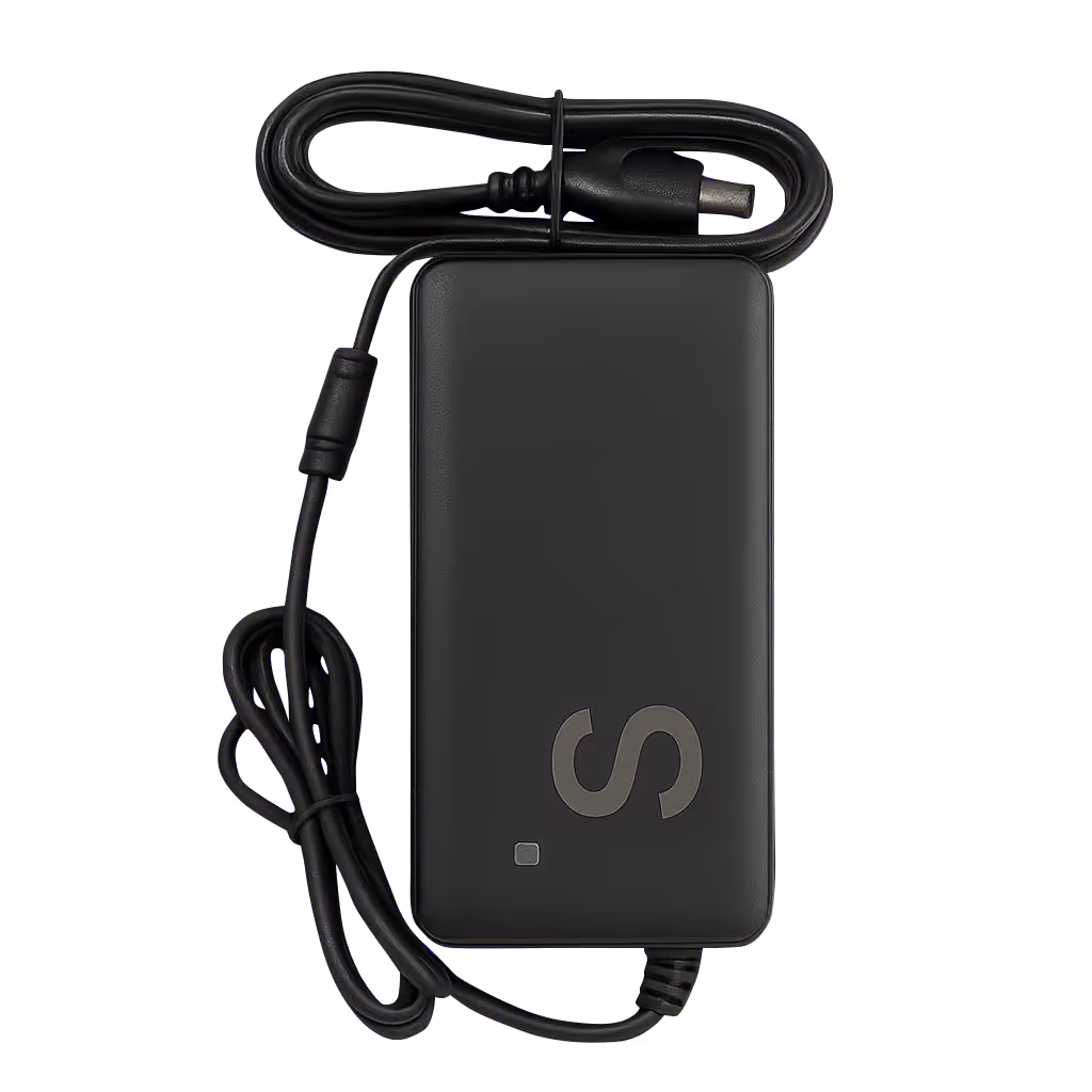 Black rectangular laptop charger with attached power cable coiled on top and a cord wrapped around the device.