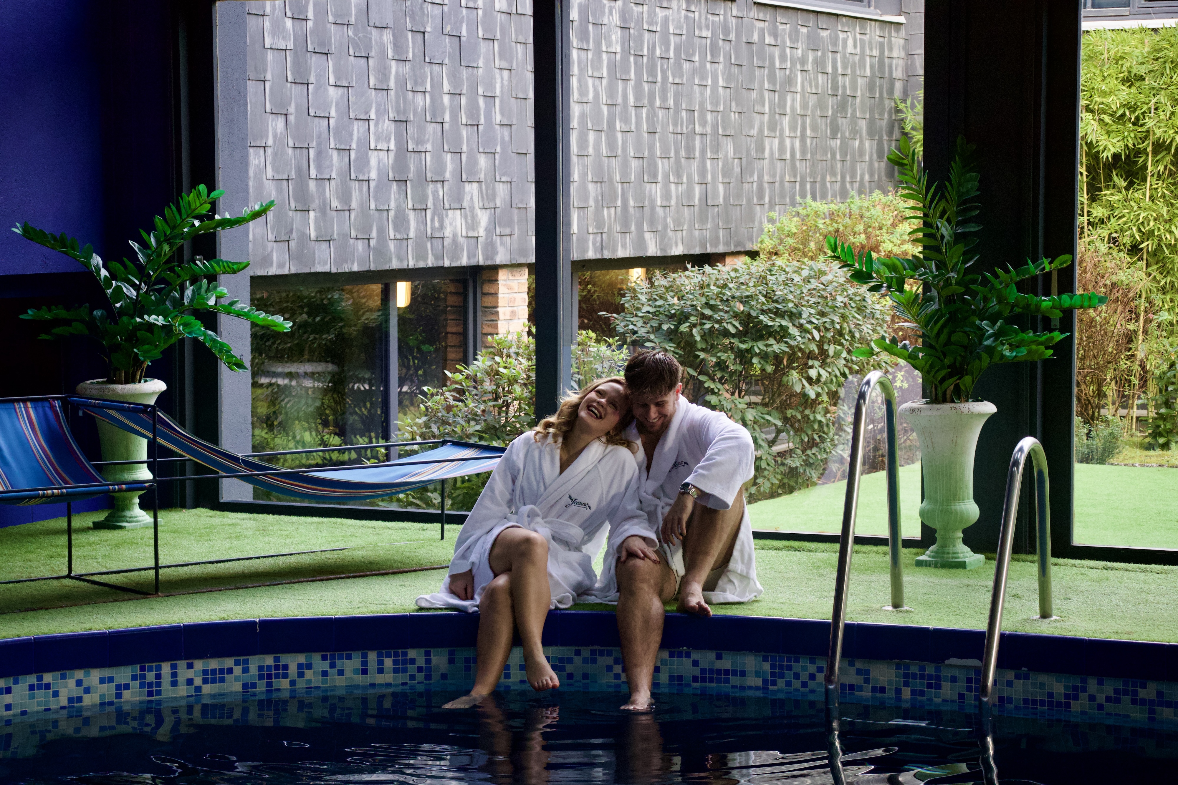 Couple profitant d'un moment de détente au bord de la piscine du spa de Jeanne & The Forest, près de Chantilly.