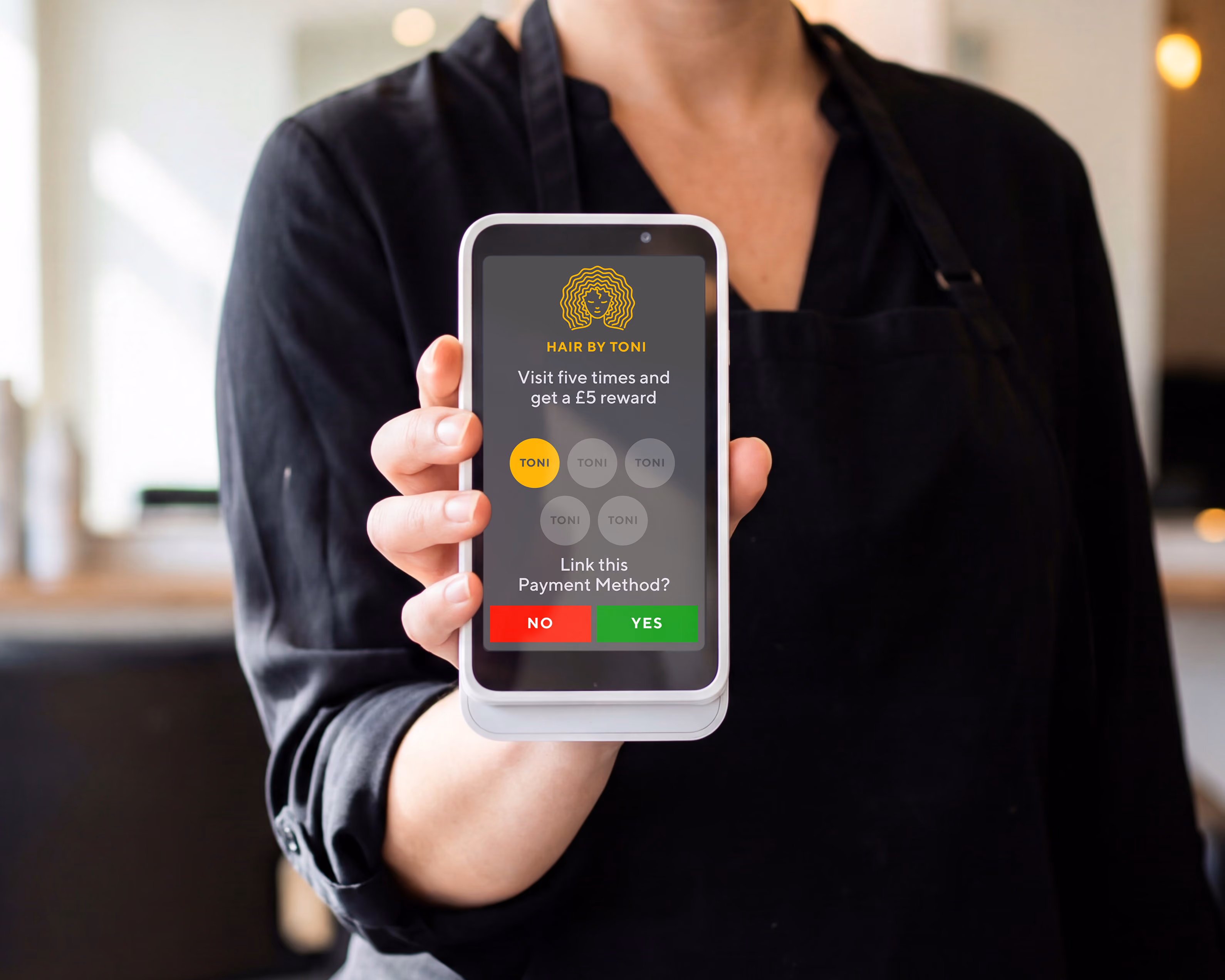 Person in black holds Stripe S700 payment terminal displaying loyalty rewards app.