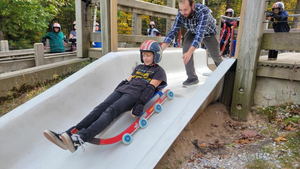 A student being pushed down the Muskegon Luge.