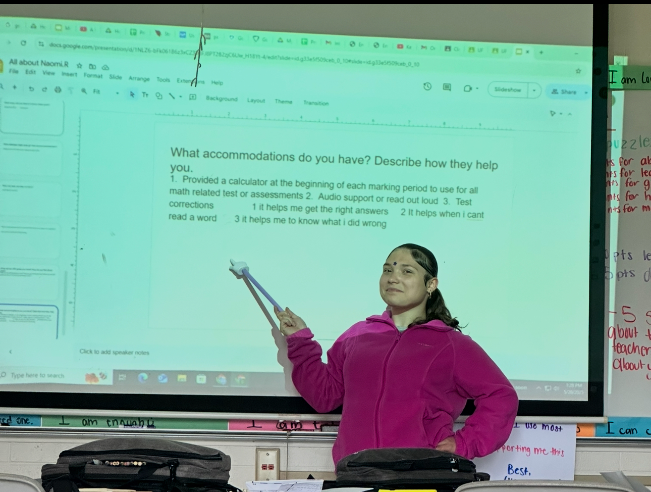 A student holding their hand up to a presentation.