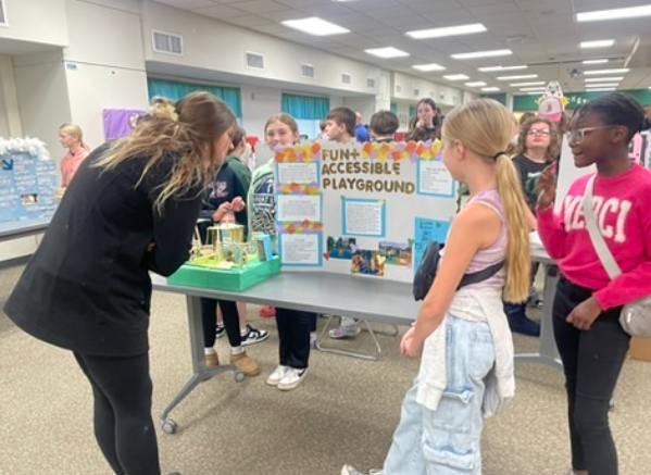 Students showcasing their project at an accessibility fair.