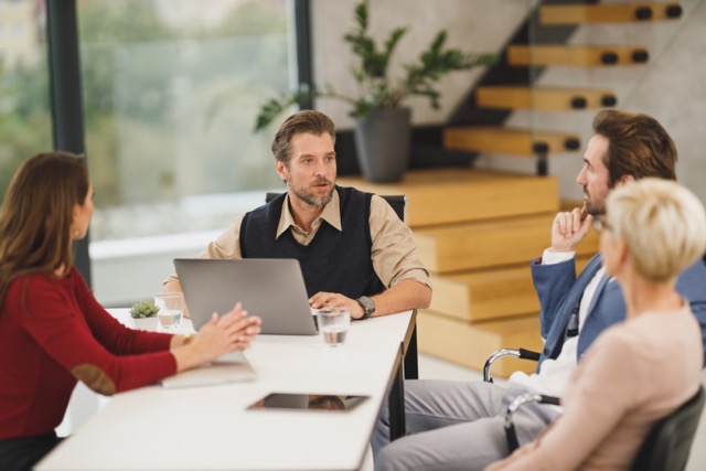 Group of coworkers sitting around meeting table