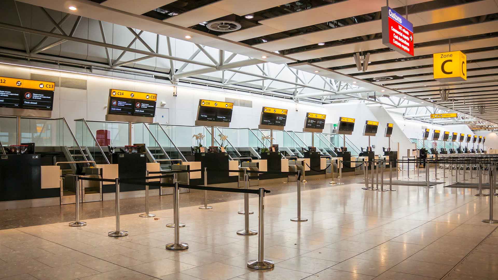 Rows of empty check-in desks in a UK airport terminal
