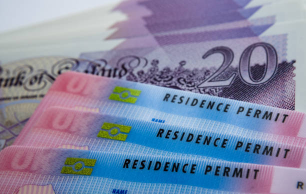 UK biometric residence permit cards on top of a £20 note