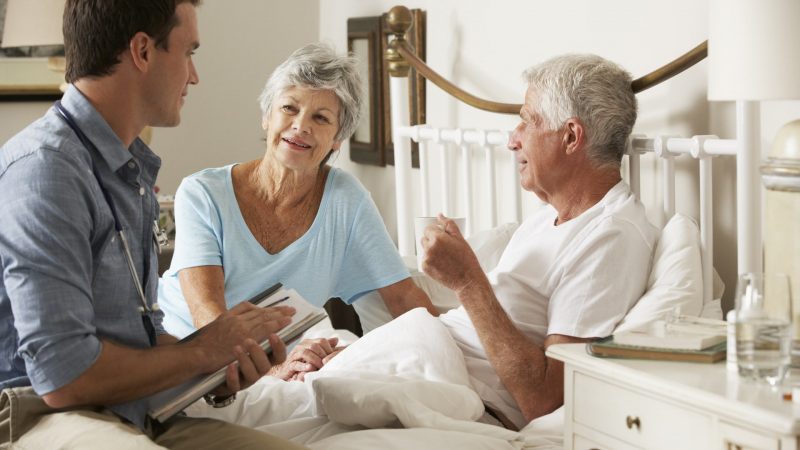 A care worker visiting an older couple at home