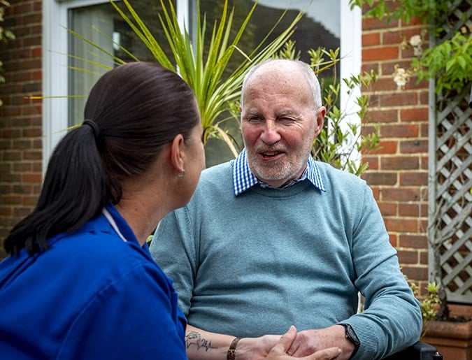 An Embracing Care worker talking with an older man outside his home