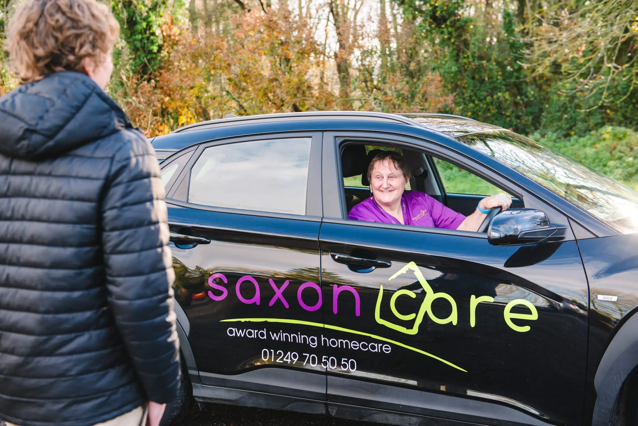 A Saxon Care worker in a branded company car
