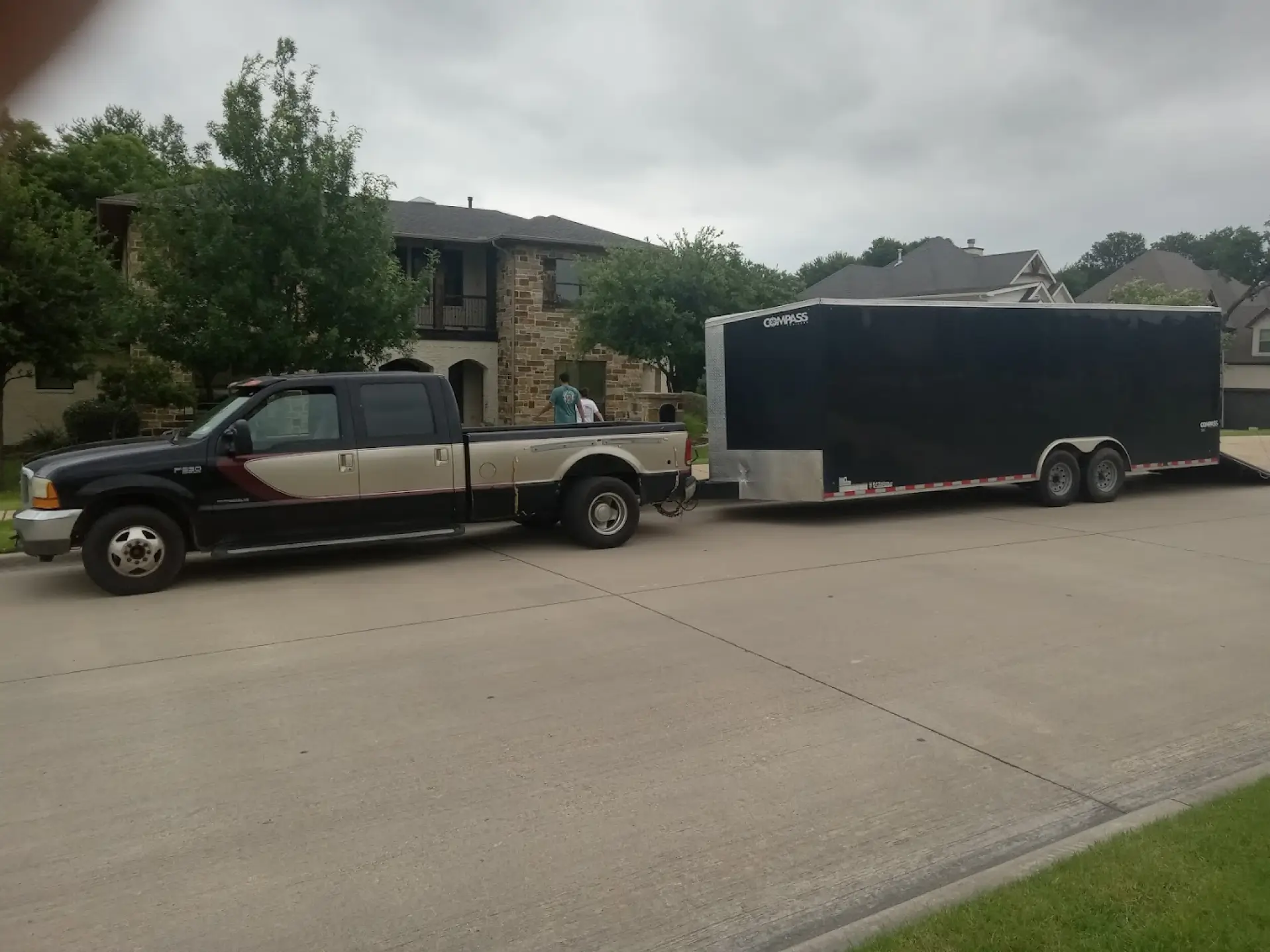 A pickup truck with a large moving trailer outside a home