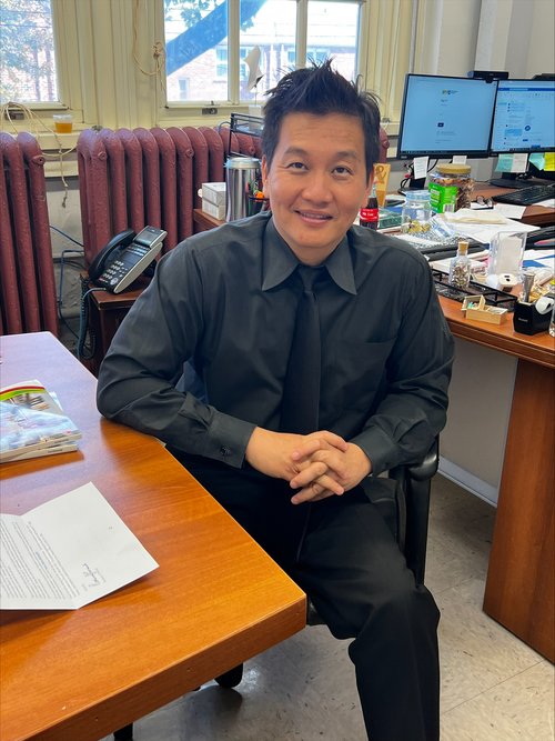 Principal or administrator seated at desk in school office